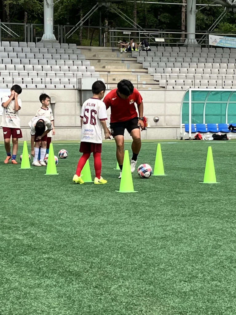 Kilian berlatih dribel antar-cone bersama coach FC Seoul Academy